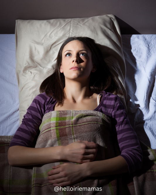 Image of a woman laying wide awake in bed.